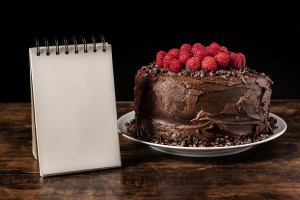 عکس با کیفیت کیک شکلاتی با توت فرنگی همراه با دفترچه منو